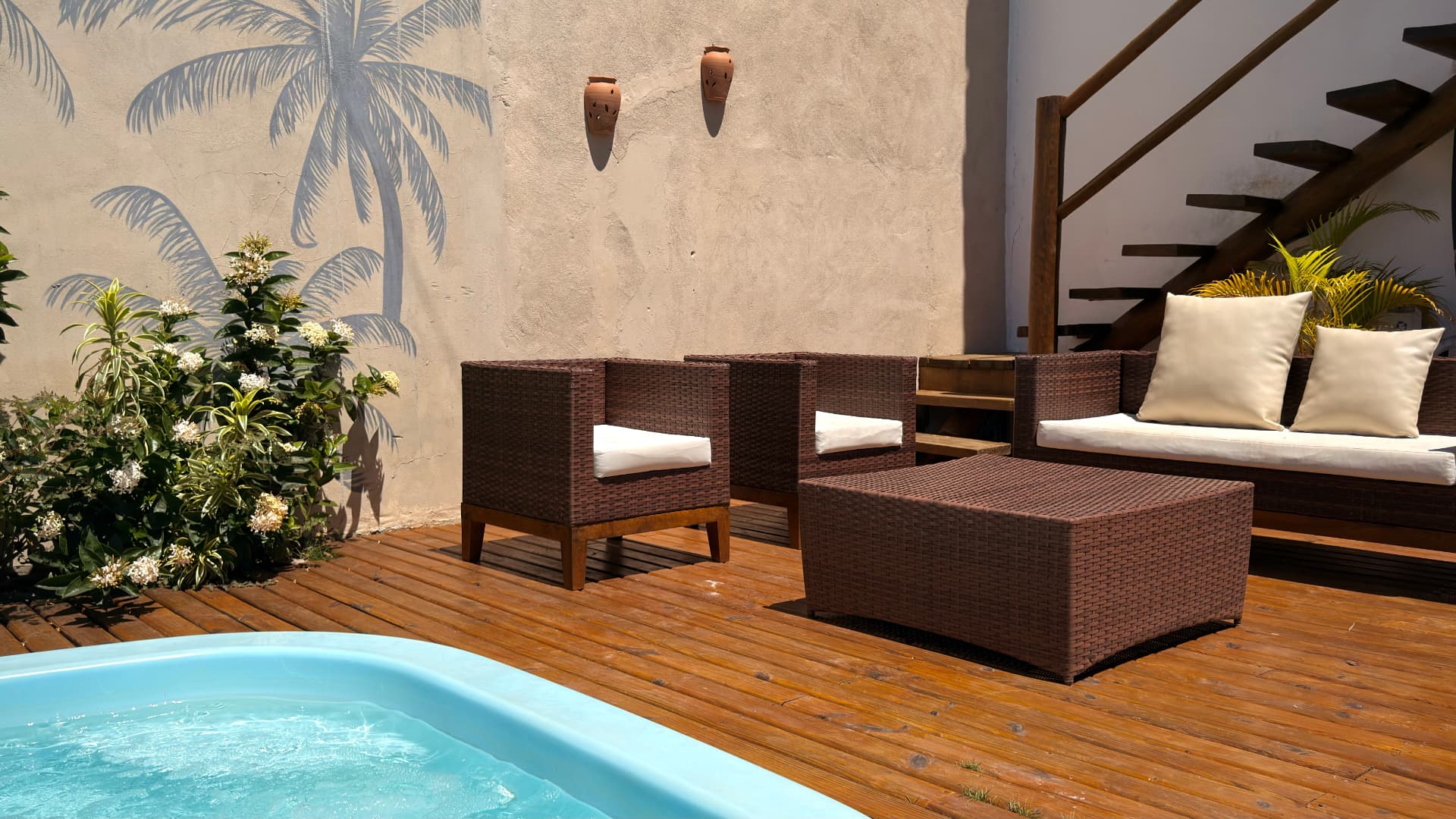 Deck de madeira com poltronas ao lado da piscina