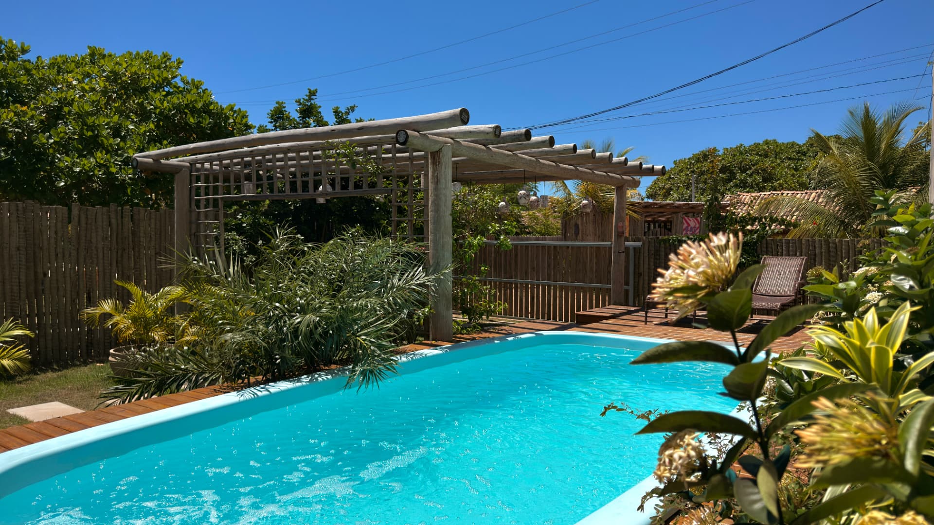Piscina cercada por flores e plantas tropicais