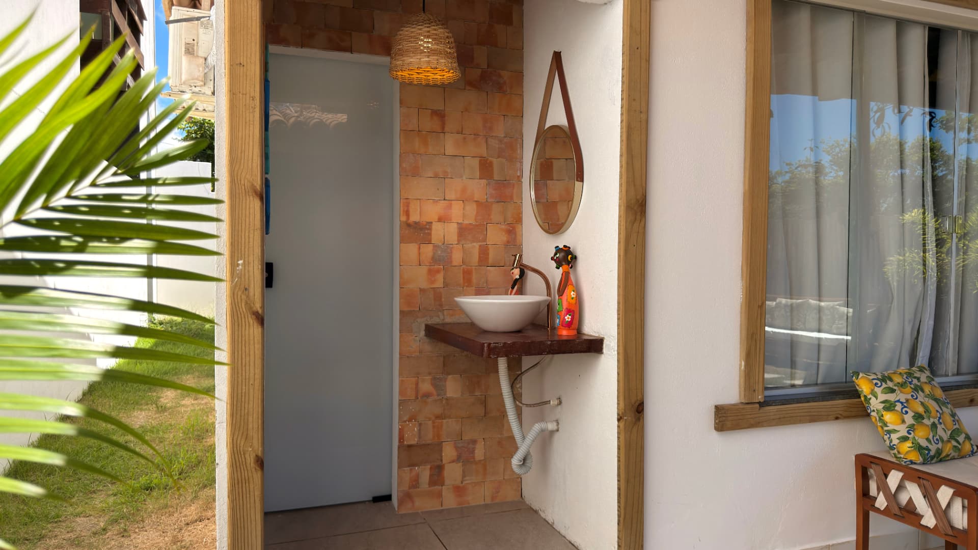 Lavabo externo em tijolinhos com espelho redondo